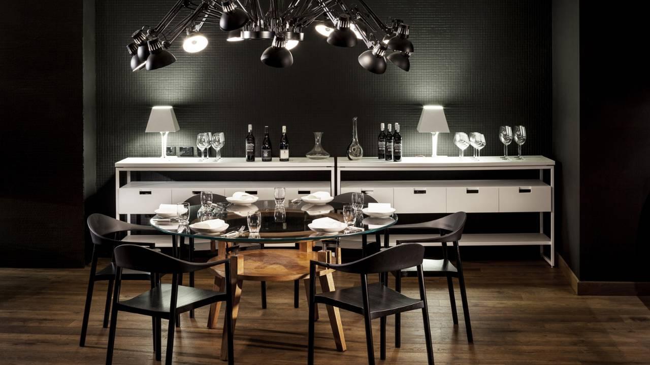 Four Seasons Hotel Сидней Экстерьер фото The photo features a modern dining area with a sleek and contemporary design. In the center, there's a round glass dining table set with white plates and elegant glassware. Surrounding the table are several black chairs with minimalist designs.

On o